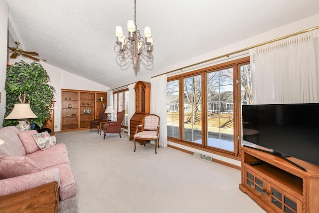 living room with a textured ceiling, ceiling fan with notable chandelier, light colored carpet, and vaulted ceiling