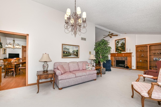 carpeted living room with a textured ceiling, lofted ceiling, ceiling fan with notable chandelier, and a brick fireplace