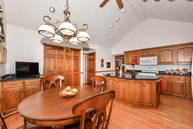 dining area with high vaulted ceiling, ceiling fan with notable chandelier, sink, beamed ceiling, and light hardwood / wood-style floors