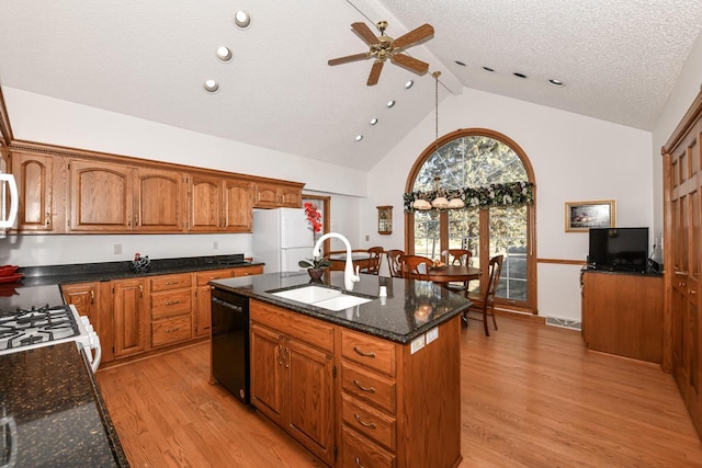 kitchen featuring lofted ceiling, white appliances, a center island with sink, sink, and a textured ceiling