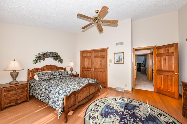 bedroom featuring ceiling fan, wood-type flooring, and a textured ceiling