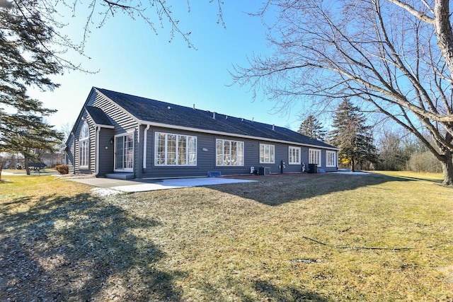 rear view of house featuring a lawn and a patio area