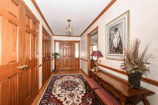 entryway with an inviting chandelier, light hardwood / wood-style flooring, and ornamental molding