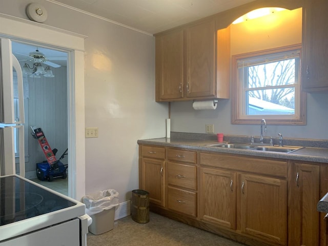 kitchen featuring ceiling fan, stove, and sink