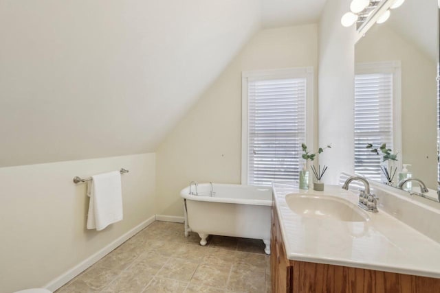 bathroom featuring a bath, vanity, and lofted ceiling