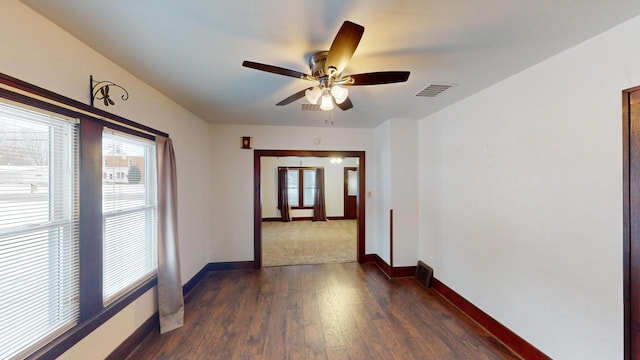 empty room with ceiling fan and dark hardwood / wood-style flooring