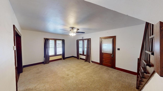 carpeted spare room featuring ceiling fan