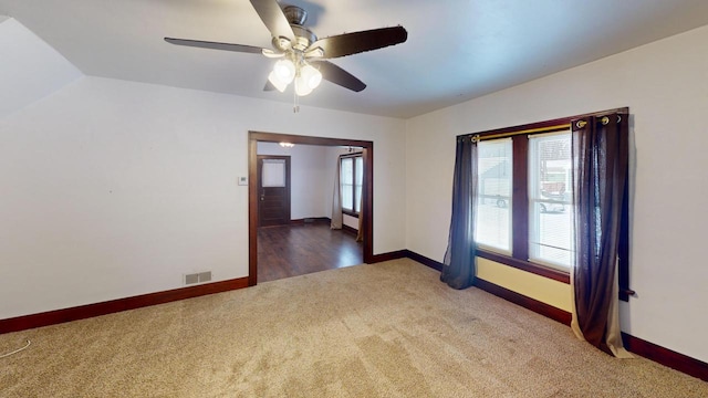 carpeted empty room featuring ceiling fan and vaulted ceiling