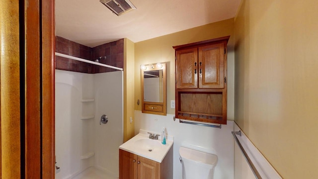 bathroom featuring vanity, toilet, and walk in shower