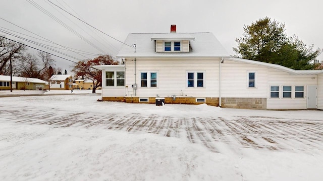 view of snow covered back of property