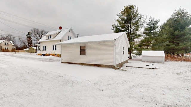 view of snowy exterior with an outbuilding