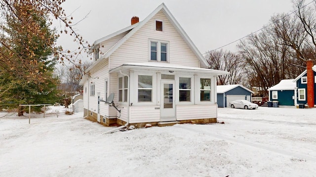 view of front facade with a garage and an outbuilding