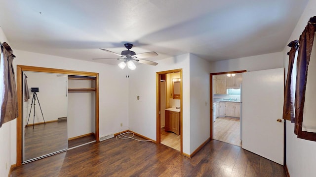 unfurnished bedroom with ceiling fan, dark hardwood / wood-style flooring, connected bathroom, and a closet