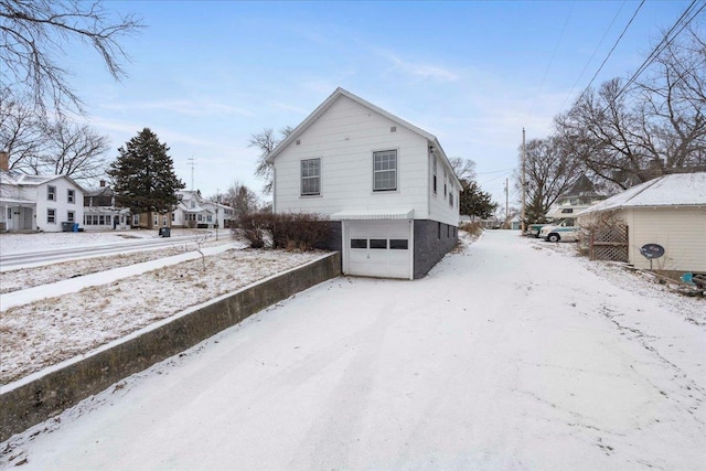 view of snowy exterior featuring a garage