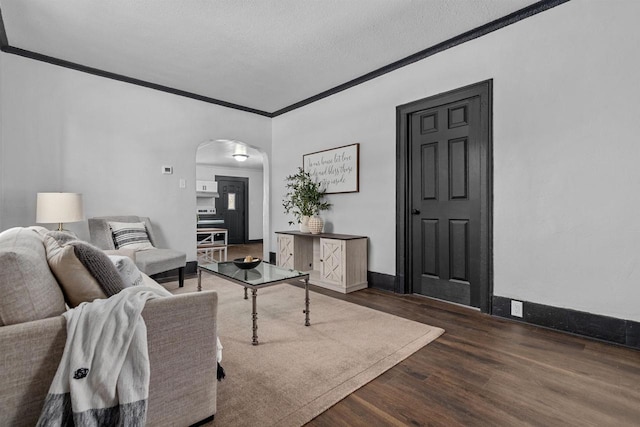 living room featuring a textured ceiling, crown molding, and dark wood-type flooring