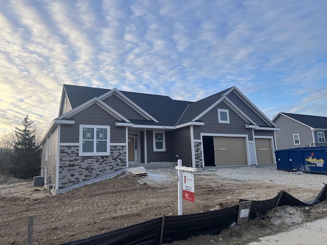 view of front of home with a garage and central air condition unit