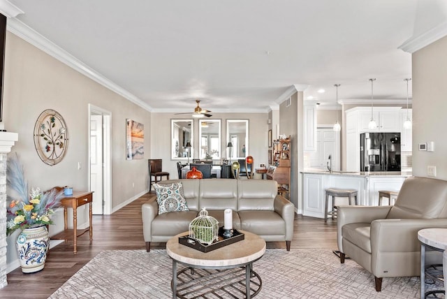 living room featuring wood-type flooring, ceiling fan, and crown molding