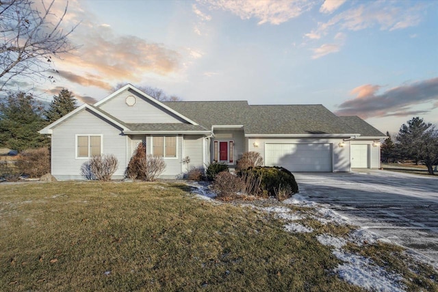 ranch-style house with a garage and a yard