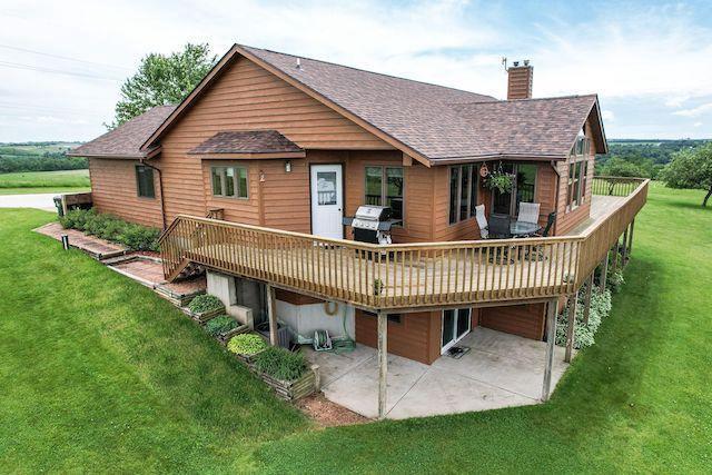 back of property featuring a yard, a deck, and a patio area