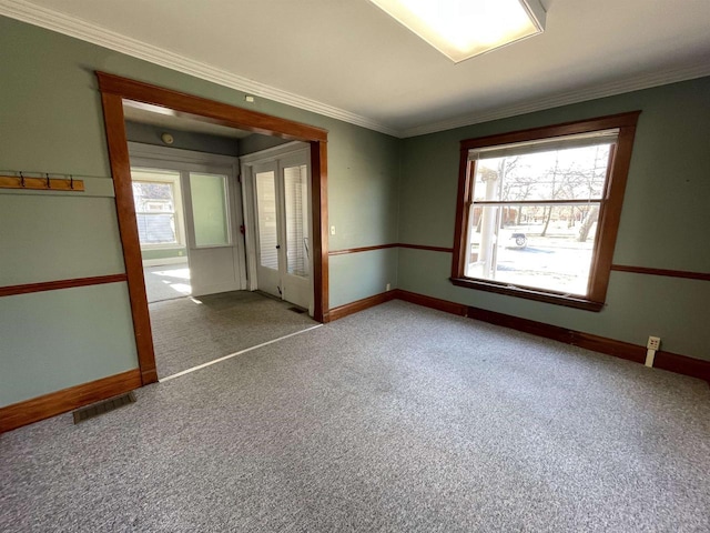 spare room with carpet flooring, a healthy amount of sunlight, and ornamental molding