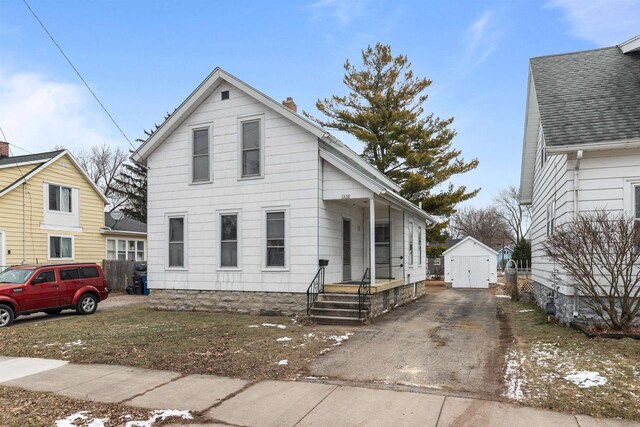 view of front of property featuring a storage shed