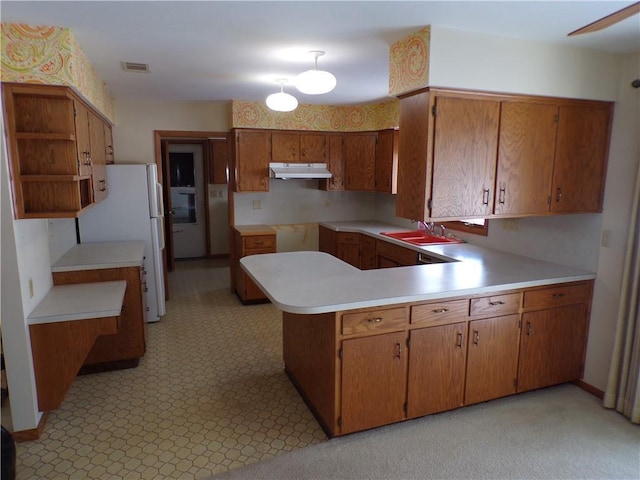 kitchen featuring kitchen peninsula, sink, and white refrigerator