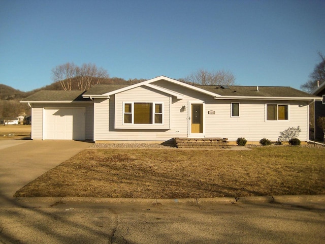 ranch-style home featuring a garage and a front lawn