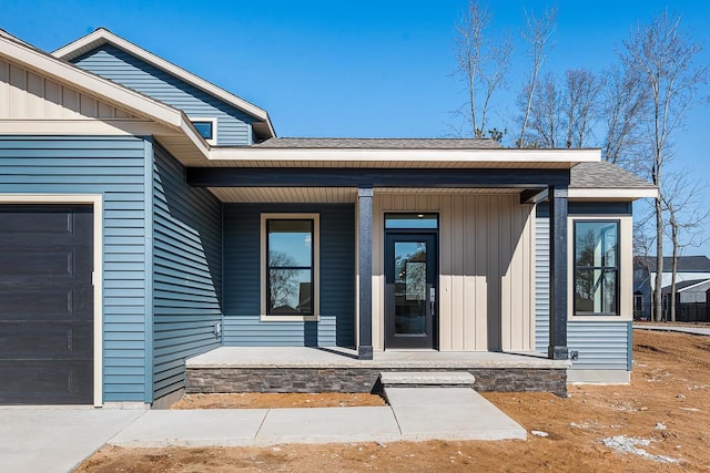 doorway to property featuring covered porch and a garage