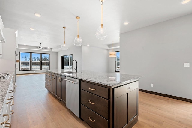 kitchen featuring light hardwood / wood-style flooring, pendant lighting, stainless steel appliances, an island with sink, and ceiling fan