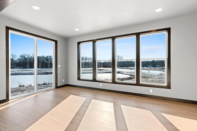 empty room featuring light hardwood / wood-style floors and a water view