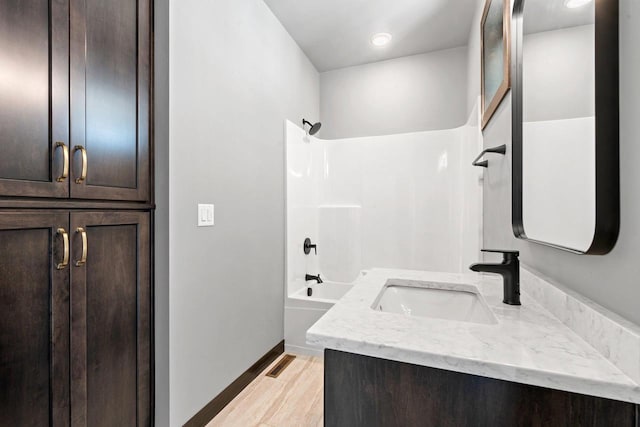 bathroom with vanity, hardwood / wood-style flooring, and bathing tub / shower combination