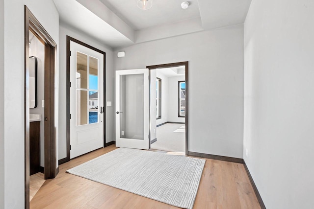 hall featuring french doors and light wood-type flooring