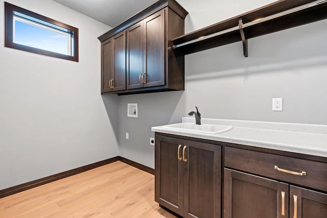 laundry room with cabinets, light hardwood / wood-style floors, hookup for an electric dryer, washer hookup, and sink