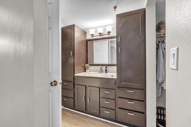 bathroom with hardwood / wood-style flooring, vanity, and an inviting chandelier