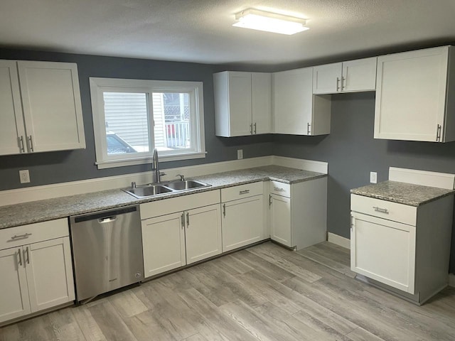 kitchen with dishwasher, light hardwood / wood-style flooring, white cabinetry, and sink