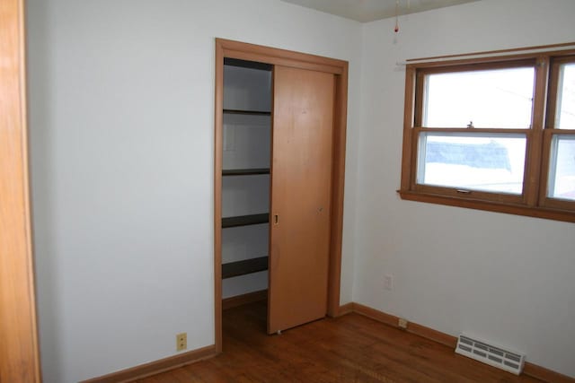 unfurnished bedroom featuring dark hardwood / wood-style flooring