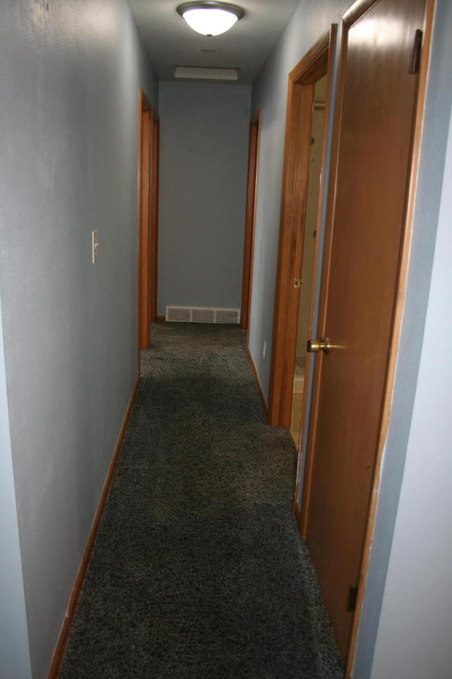 hall featuring dark carpet