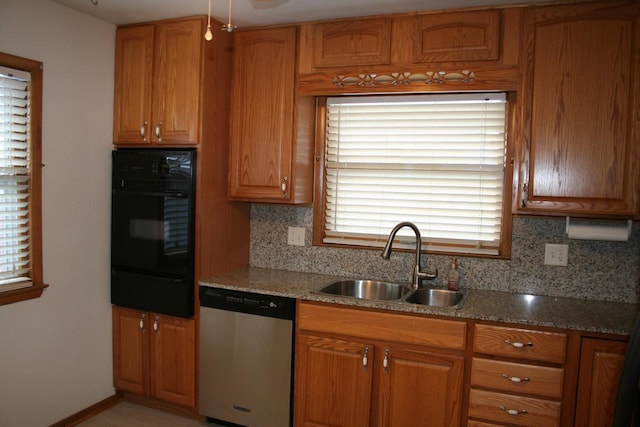 kitchen with decorative backsplash, light stone counters, stainless steel dishwasher, and sink