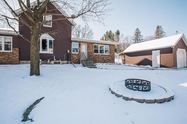 view of front of home featuring a garage, an outdoor fire pit, and an outdoor structure