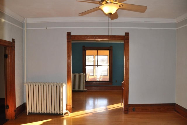 empty room with ceiling fan, ornamental molding, and radiator