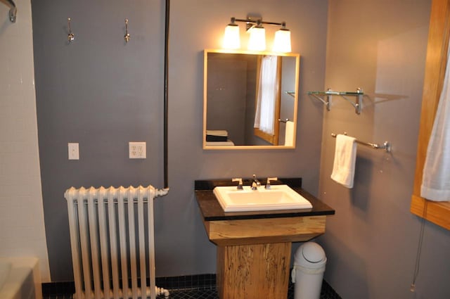 bathroom featuring radiator heating unit, a tub, and sink