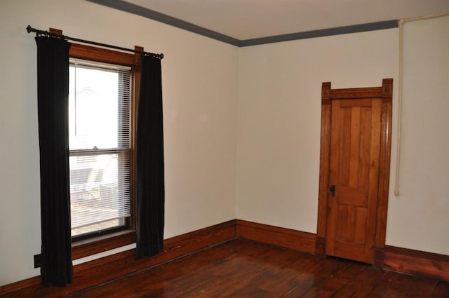 empty room featuring crown molding and dark wood-type flooring