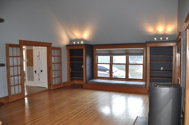 unfurnished living room featuring french doors, vaulted ceiling, and hardwood / wood-style flooring