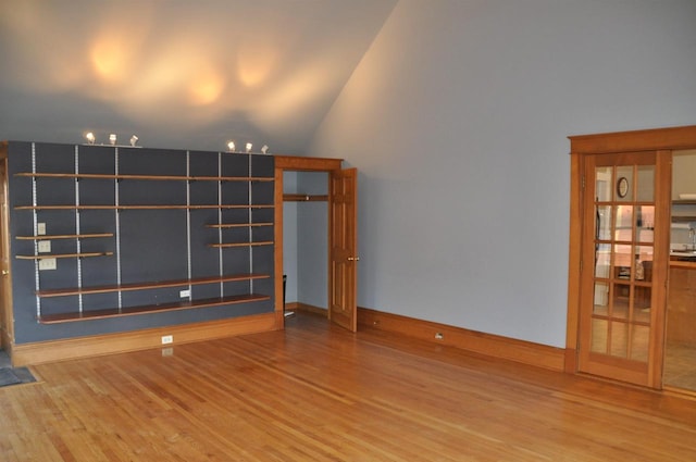 unfurnished living room featuring wood-type flooring and vaulted ceiling