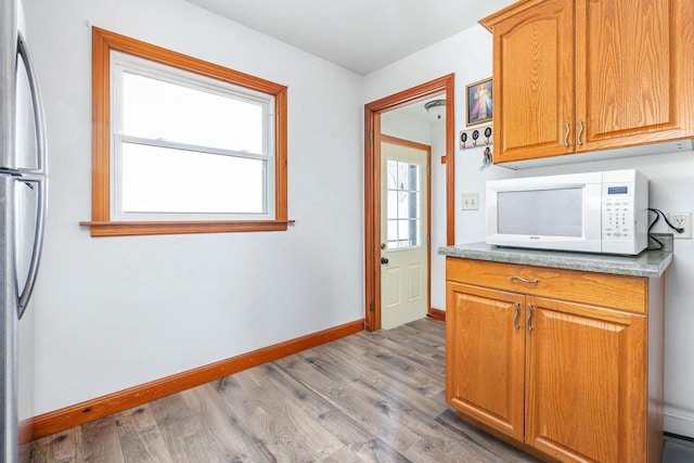 kitchen featuring stainless steel refrigerator and light hardwood / wood-style flooring