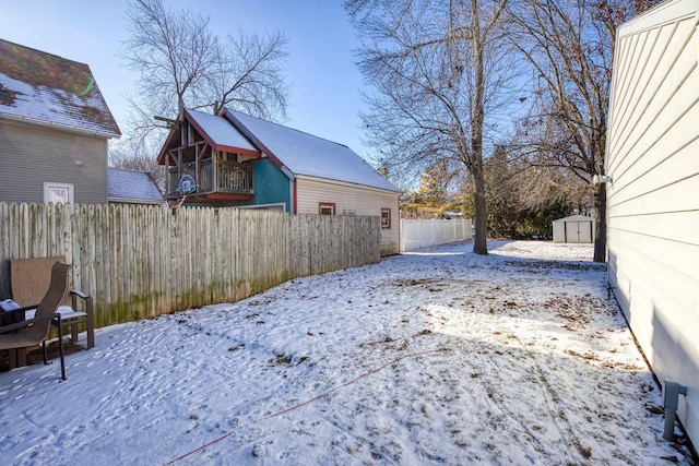 yard layered in snow featuring a storage unit