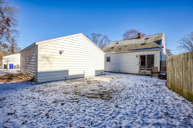 view of snow covered back of property