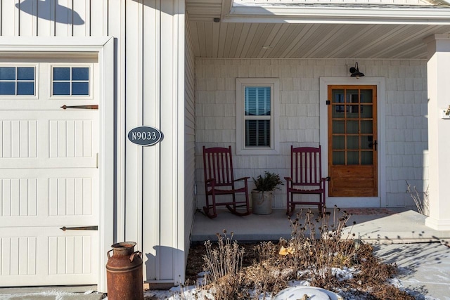 entrance to property with covered porch and a garage