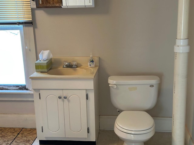 bathroom featuring tile patterned floors, vanity, toilet, and a healthy amount of sunlight