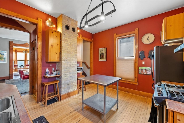 kitchen with sink, gas range, and light hardwood / wood-style floors